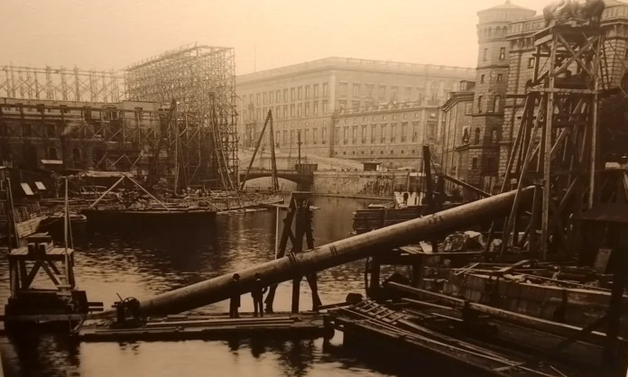 Installation of a water pipeline in central Stockholm. In the background, the Parliament House under construction.