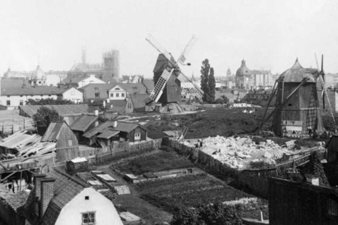 The Barnhus mills in Tegnérlunden, which were demolished in 1890. In the background, the construction of Johannes Church can be seen, inaugurated in May 1890.