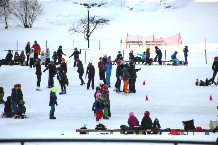 Children enjoying ice-skating on the football field at Vasaparken in Stockholm.